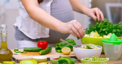 pregnant woman making salad